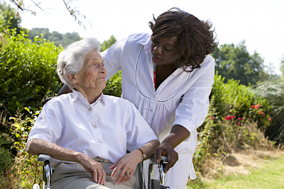 caregiver talking to a senior woman on wheelchair